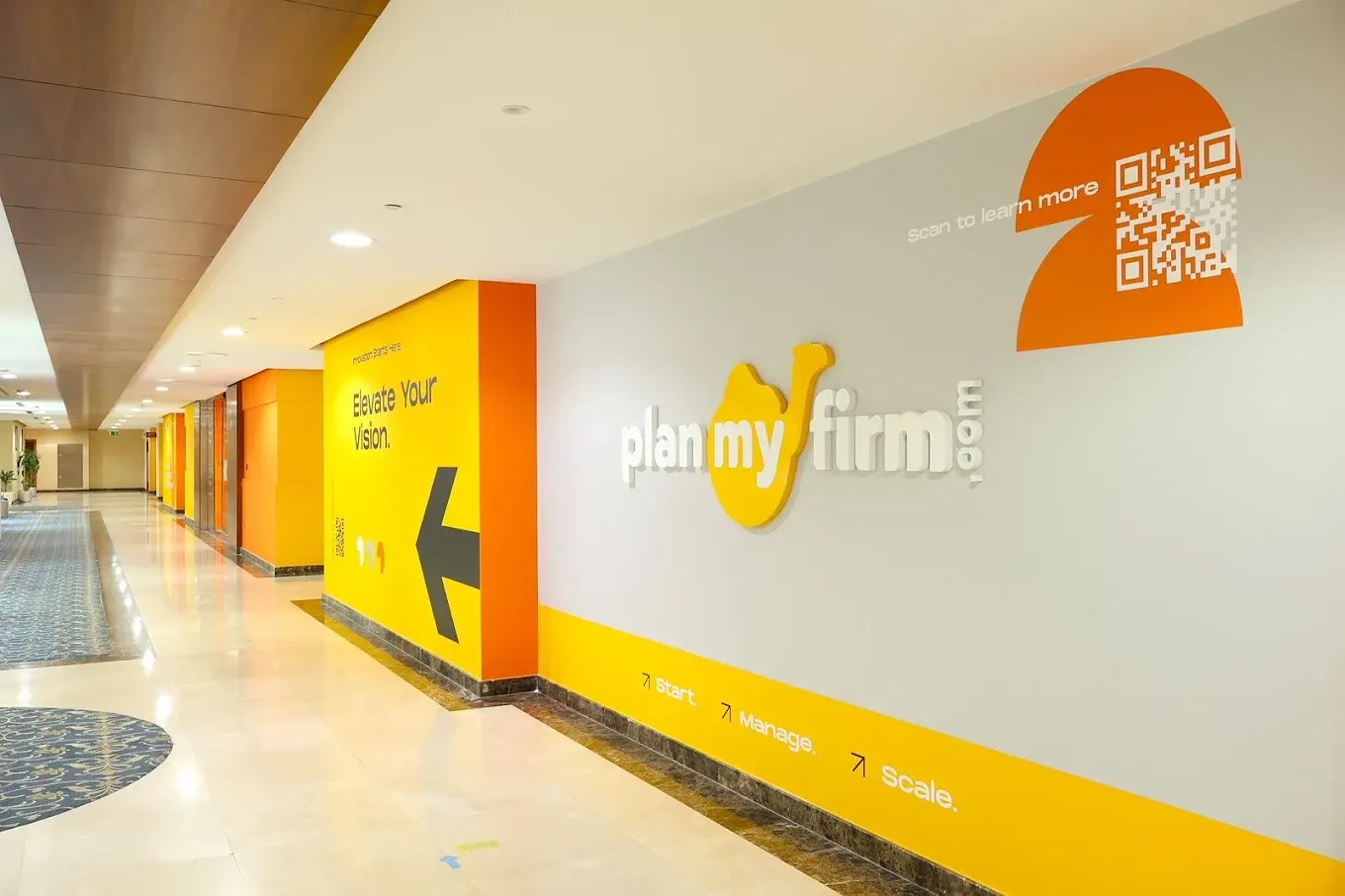 PlanMyFirm logo wall in the Business Village corridor, Deira