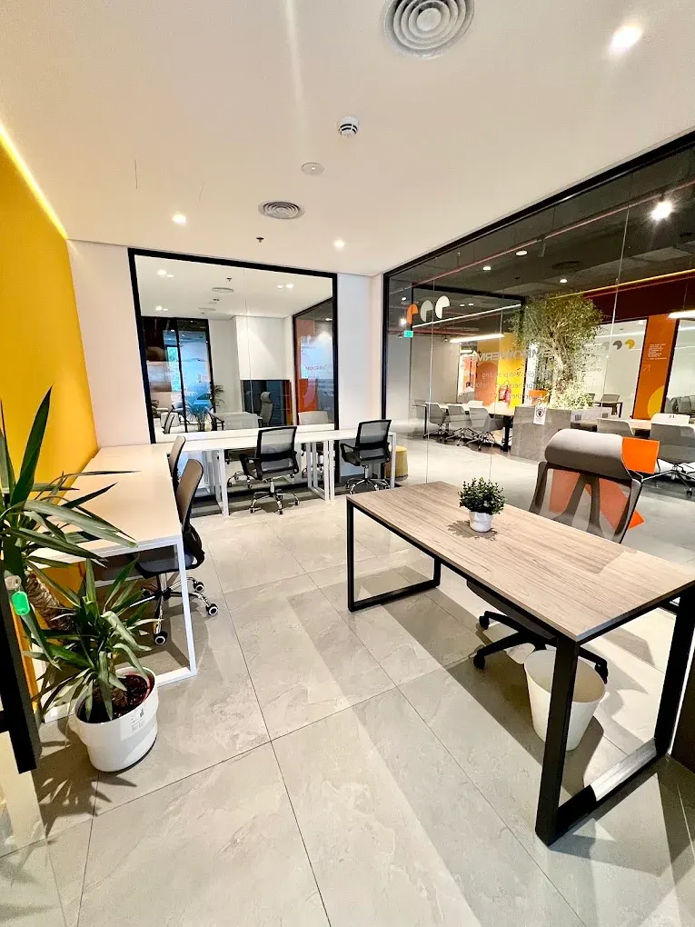 Shared desks beside a yellow feature wall